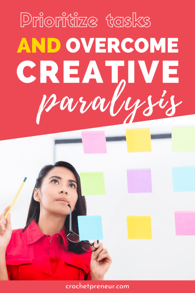 Woman looking thoughtfully at sticky notes on a wall. Text reads: Prioritize tasks and overcome creative paralysis.