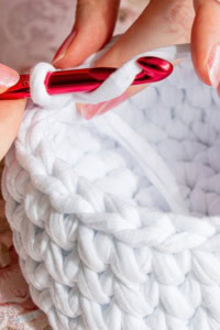 turn your hobby into a business - image of a chunky crochet basket, in progress, with a crochet hook