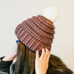 Photo of a woman turned back showing her Keystone Double Brim Hat with white pompom at the top