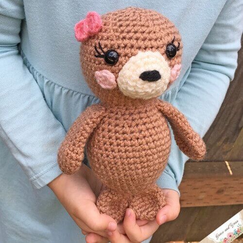 Photo of the finished Amigurumi seal pup FREE crochet pattern held by a little girl wearing a blue dress