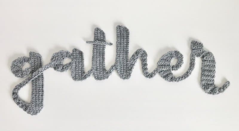 Photo of the crocheted text "gather" with a white background