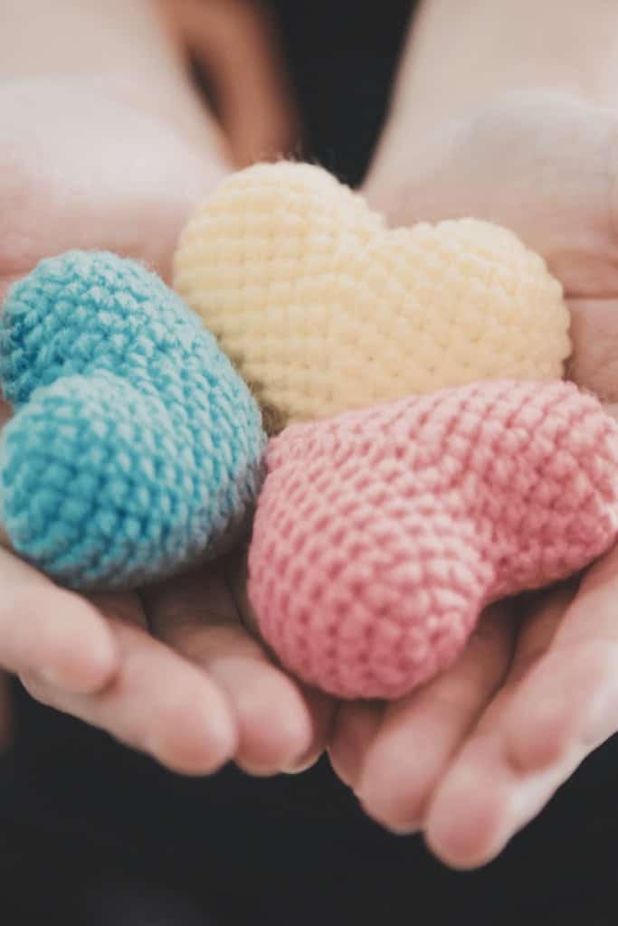 crochet designer free things - image of a pair of hands, holding 3 small amigurumi hearts