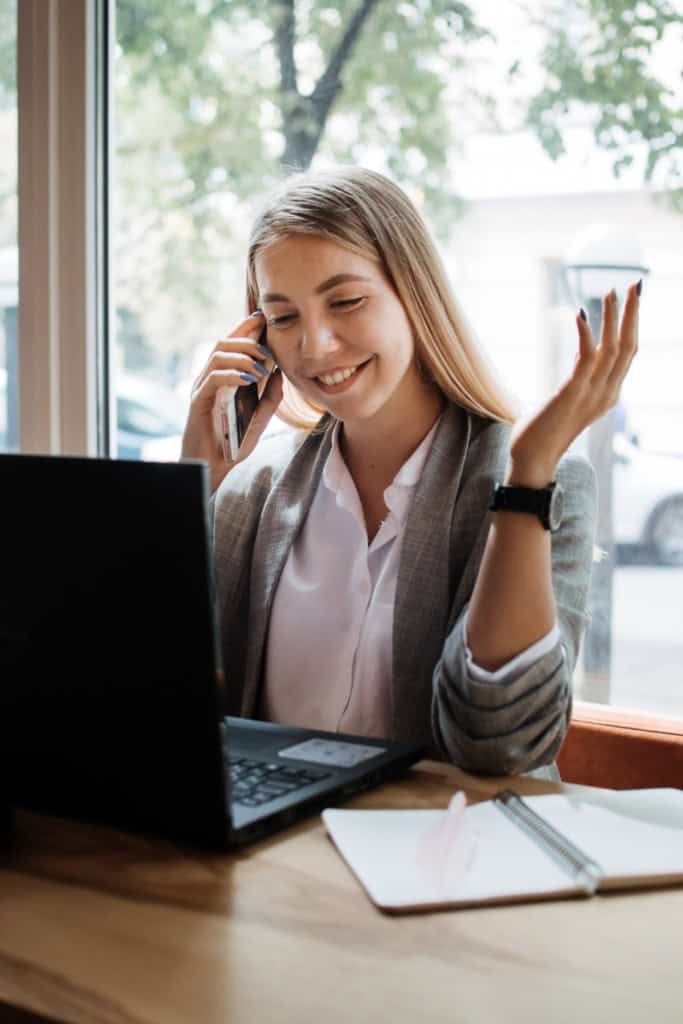 virtual assistant - image of a smiling woman sitting in front of a computer