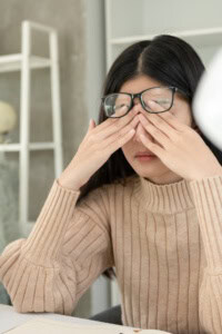 discouraged with crochet business - woman sitting at a desk with her head in her hands