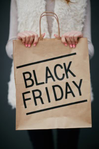 woman's hand holding a paper shopping bag with text that reads "Black Friday"