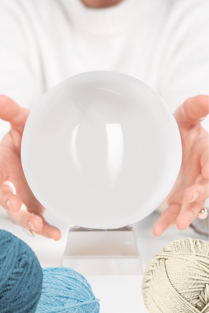 latest crochet business trends - image of hands around a crystal ball, surrounded by balls of yarn