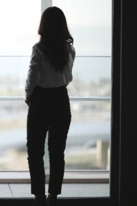 figuring out your crochet business - you don't have to do it alone - image of a lone woman looking out a window