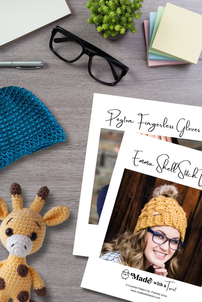 Desktop showing an assortment of crochet items and patterns, plus office supplies