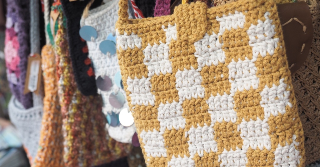 An assortment of crochet bags, displayed for sale